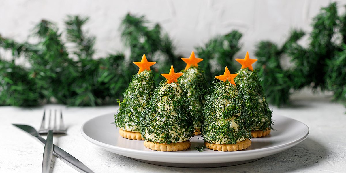 Festive salad of dill cheese and cookies in the form of a Christmas tree. Holiday appetizer in form of christmas tree