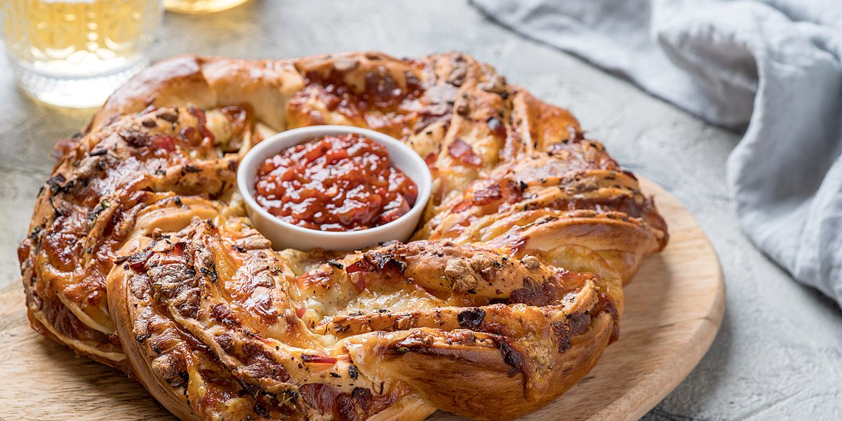 Freshly baked pizza bread wreath with bacon and cheese