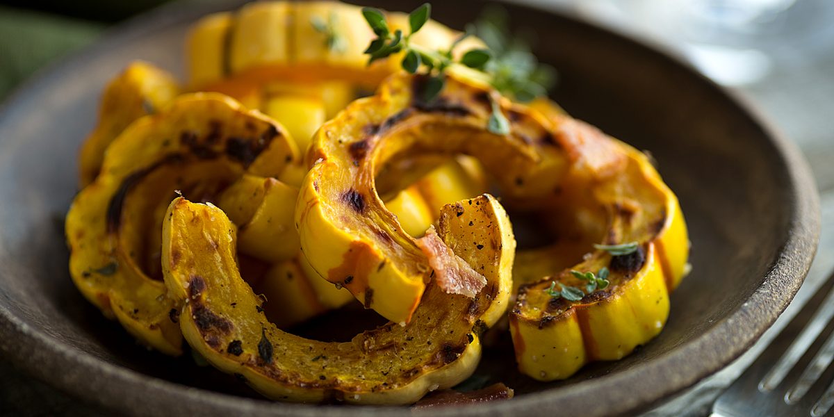 Sheet pan with freshly roasted delicata squash on parchment