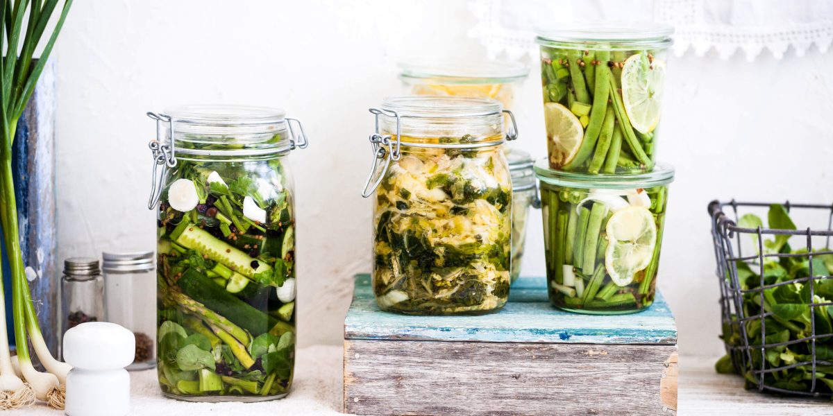 Canning concept. Cucumber fermentation in glass jars. Variety fermented green vegetables in mason jars.